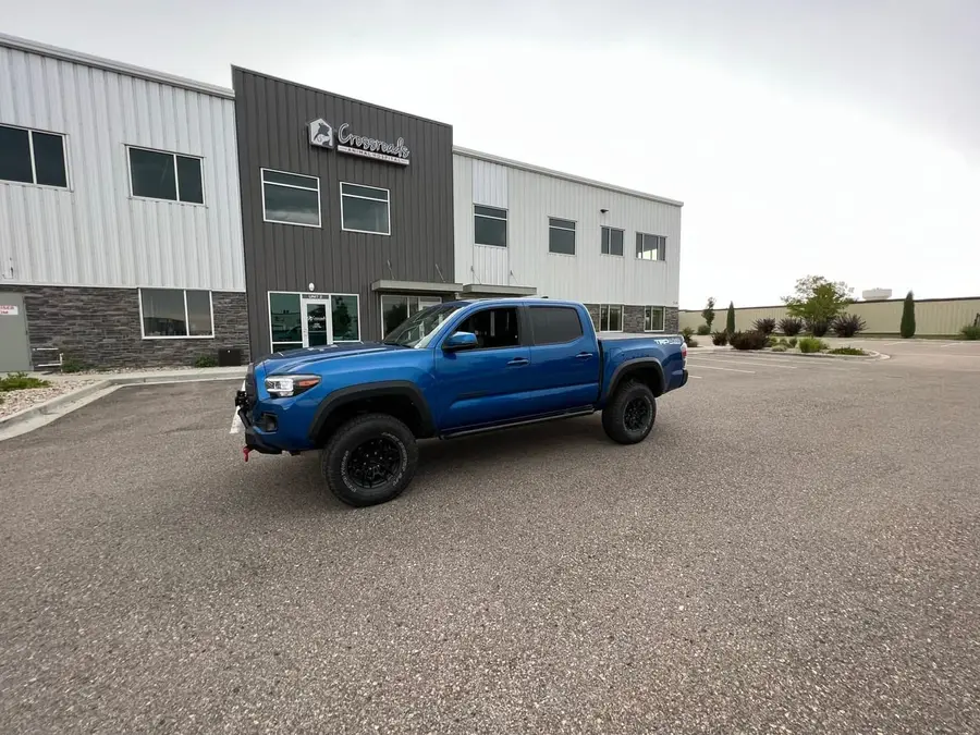 Blue Toyota Tacoma parked outside a commercial building