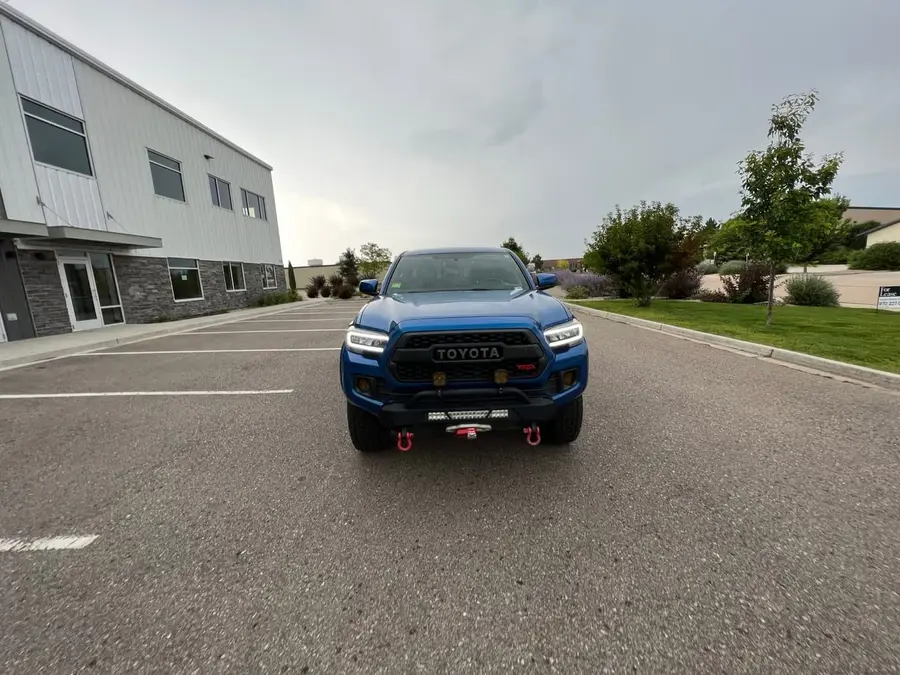 Front view of a blue Toyota Tacoma with an aftermarket front bumper