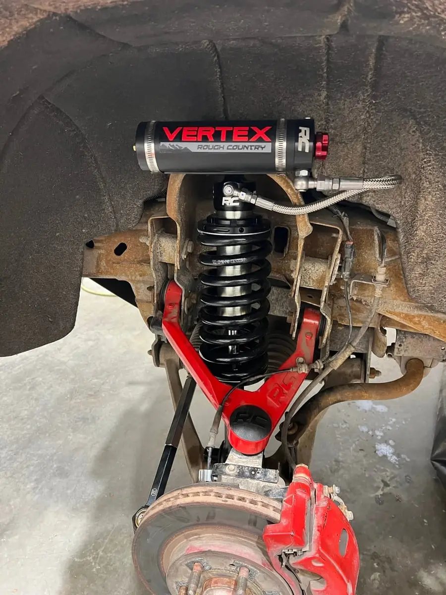 Vertex coilover with red upper control arm and brake caliper on a truck