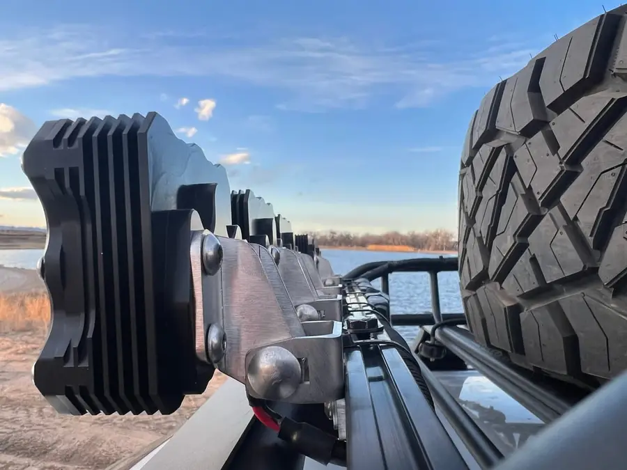 Traction boards mounted on a roof rack beside a spare tire