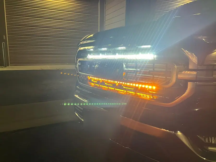 Ford F-150 at night with a grille light bar and amber lights lit