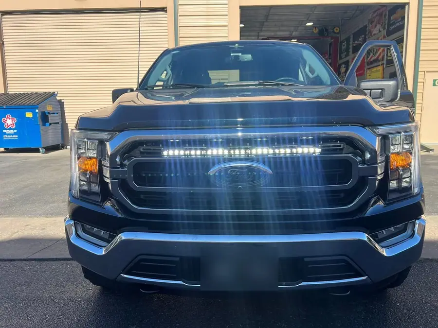 Ford F-150 with a light bar lit behind the grille