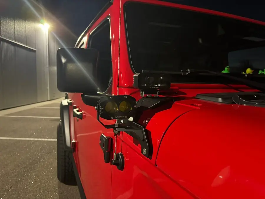 Pod light mounted on the A-pillar of a red Jeep at night