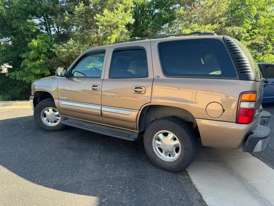 Tan Chevy Tahoe parked outside the shop