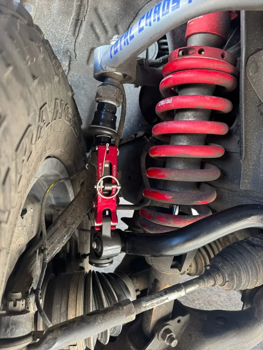 Red coilover spring and upper control arm in a truck wheel well