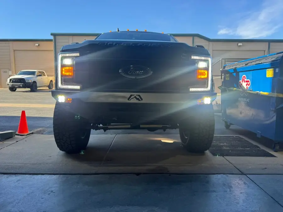 Lifted truck at dusk with headlights and fog lights on