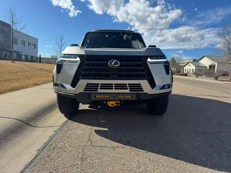 Front view of a silver Lexus GX with an aftermarket front bumper and recovery points