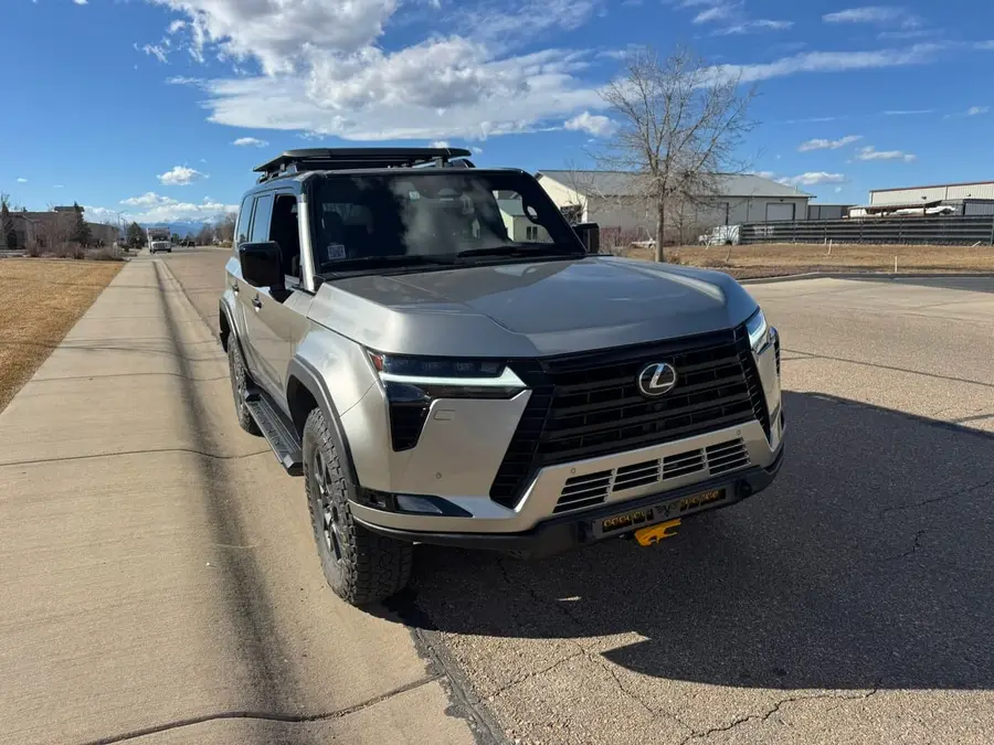 Silver Lexus GX with a roof rack and aftermarket front bumper
