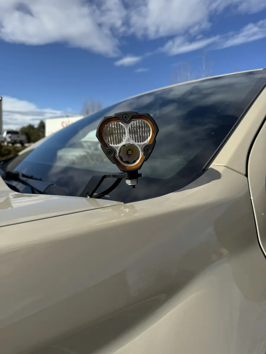 KC HiLiTES LED pod on a cowl mount at the base of a Chevy Colorado windshield