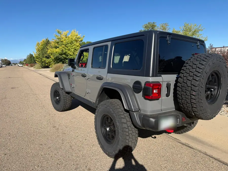 Rear three-quarter view of a lifted Jeep Wrangler Rubicon Xtreme Recon with a 37-inch spare tire