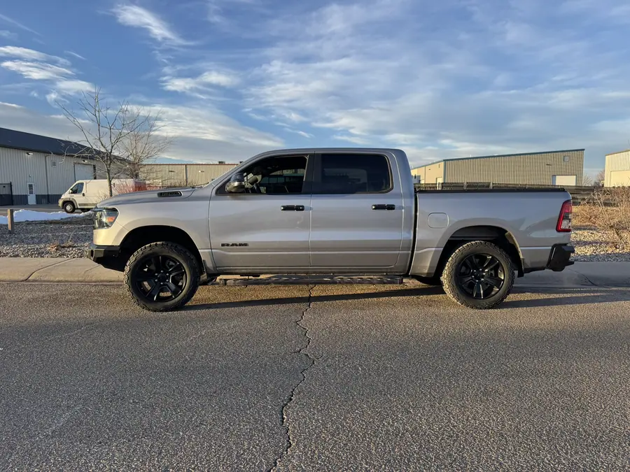 Silver 2023 Ram 1500 with a leveling kit, side view