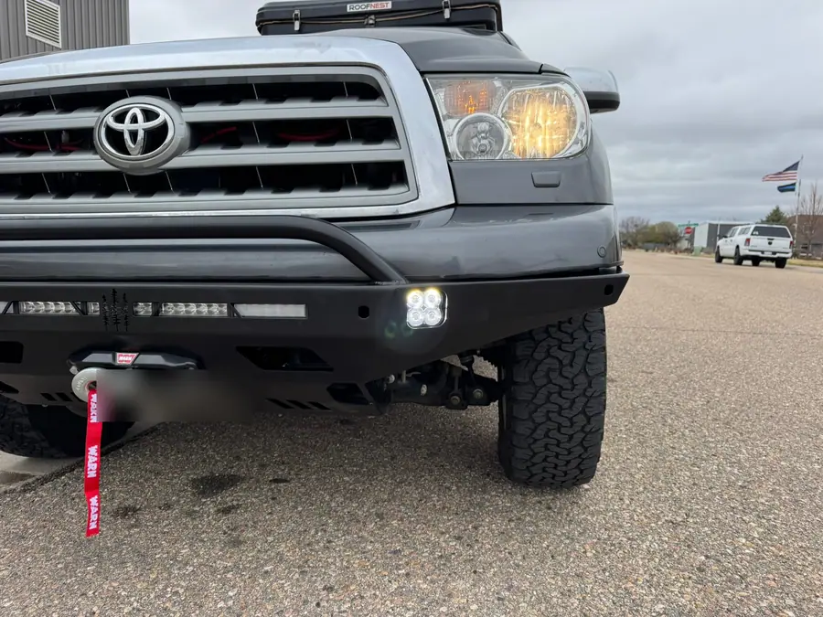 Diode Dynamics SS3 fog lights lit in the steel front bumper of a Toyota Sequoia