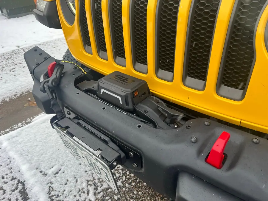 Winch fairlead and line on the front bumper of a yellow Jeep Wrangler Rubicon