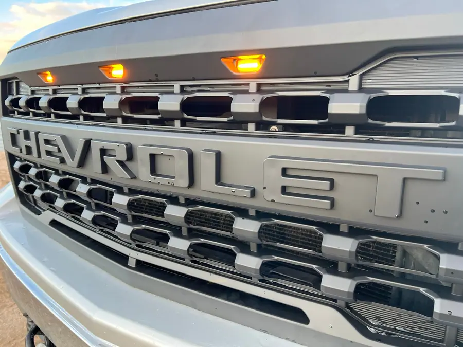 All-black grille with Raptor-style amber marker lights on a Chevy Silverado