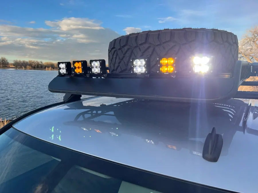 White and amber LED pods lit on the roof basket of a Chevy Silverado