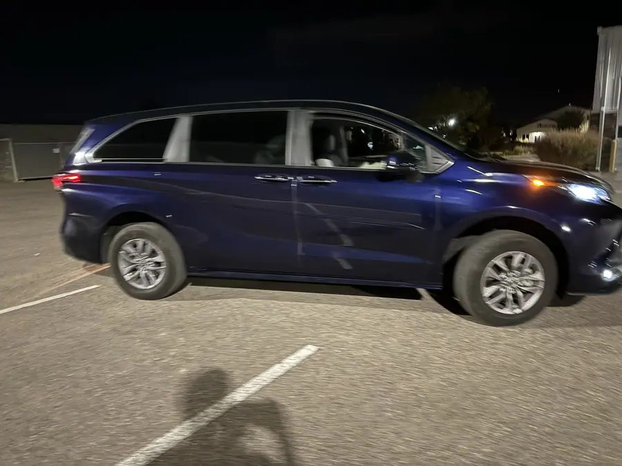 Lifted 2021 Toyota Sienna minivan rolling through a parking lot at night