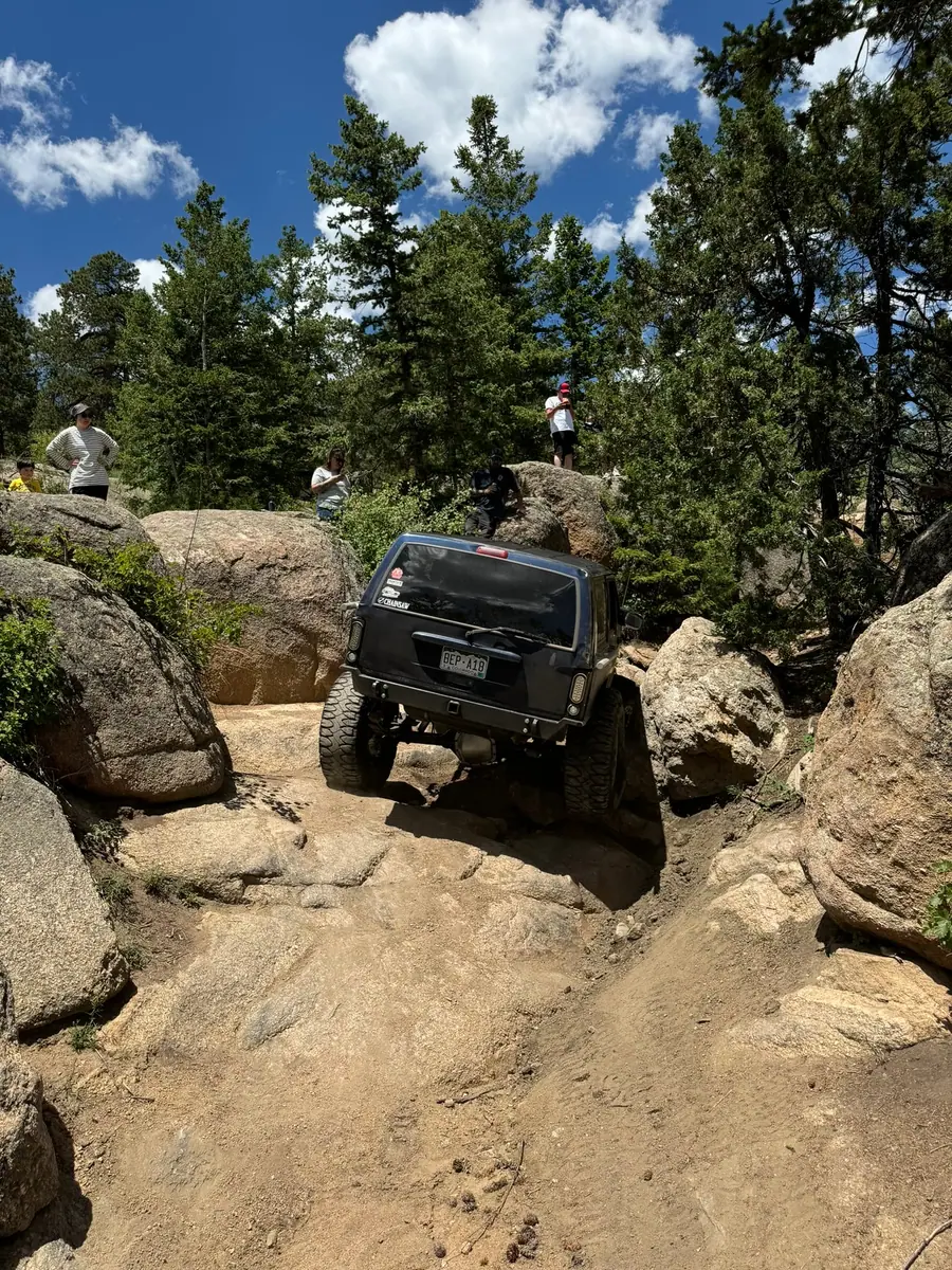 Jeep crawling down through a tight boulder section