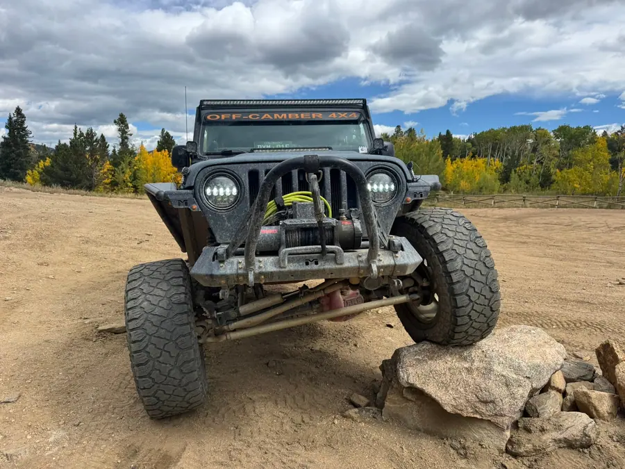 Jeep with a winch bumper nosed up on a rock
