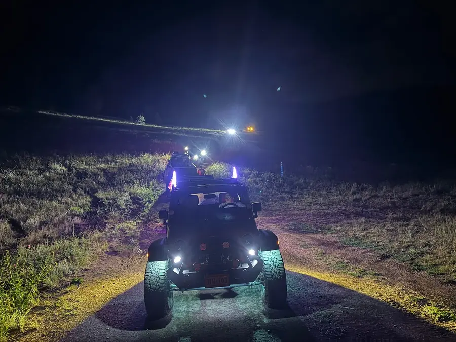 Jeep with rock lights and off-road lights on a night trail run