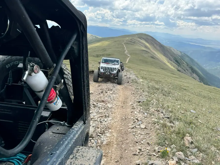 Club Jeeps following a narrow ridgeline trail