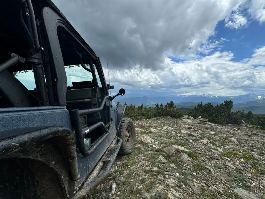 View over the hood of a Jeep from a high mountain trail
