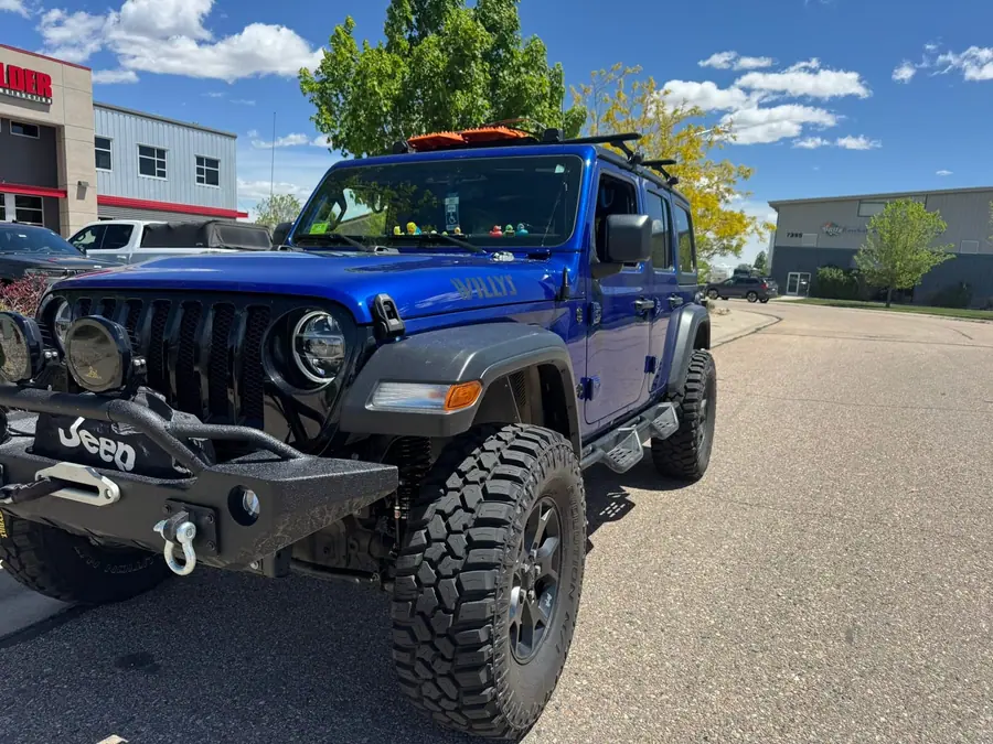 Lifted blue Jeep Wrangler JL with a winch bumper