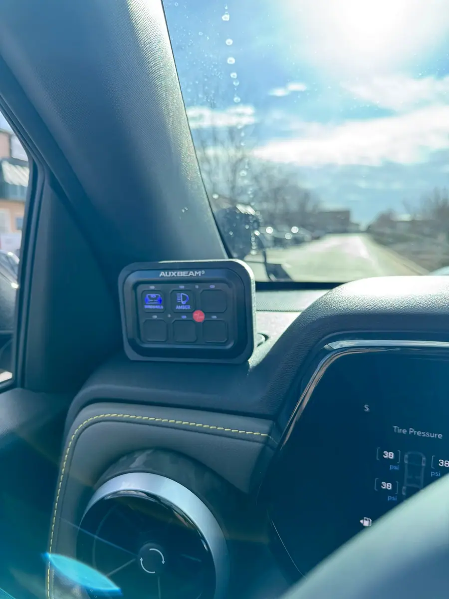 Auxiliary switch panel mounted in a truck cab