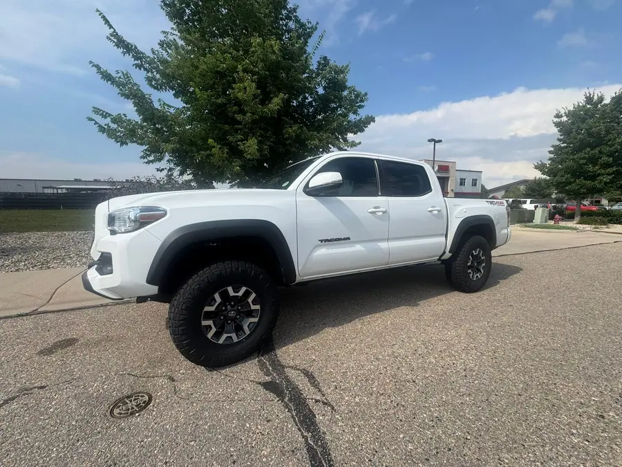 Leveled white Toyota Tacoma on all-terrain tires