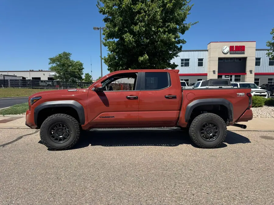 Leveled red Toyota Tacoma on all-terrain tires