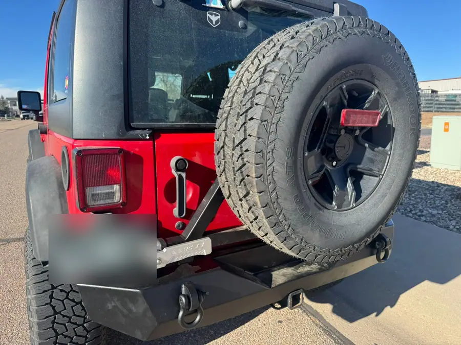 Rough Country rear bumper and tire carrier on a red Jeep Wrangler JK