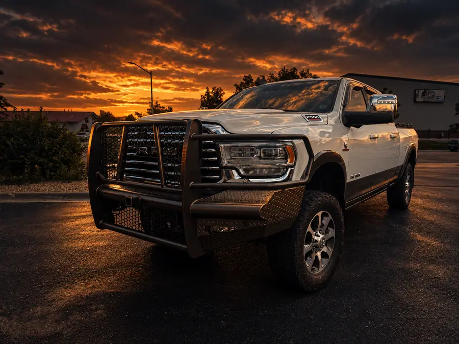 White Ram 2500 with a color-matched Ranch Hand grille guard bumper at sunset