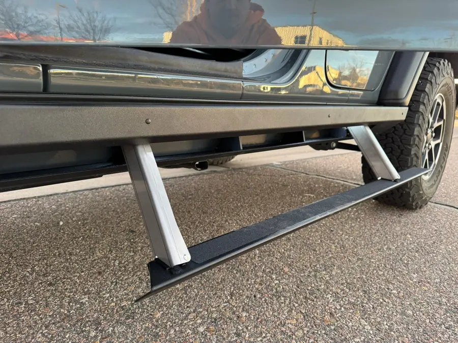 Rock Slide Engineering step slider with the step dropped down below the rocker of a Jeep Wrangler JL