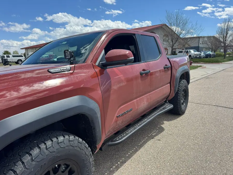 RCI Off Road rock sliders on a red 2024 Toyota Tacoma