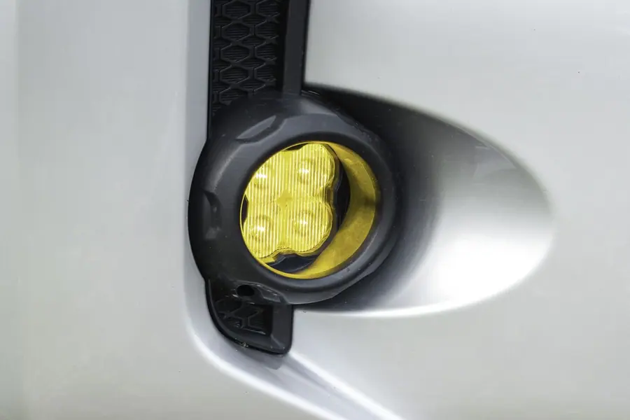 Diode Dynamics SS3 LED fog light with an SAE yellow lens installed in a factory fog light pocket