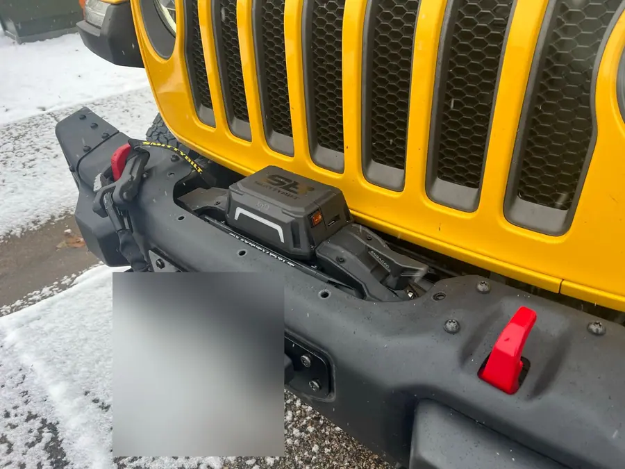 Smittybilt X2O winch mounted inside the factory steel bumper of a yellow Jeep Wrangler JL