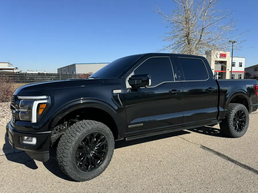 Black 14th gen Ford F-150 with a leveling kit and black wheels on all-terrain tires
