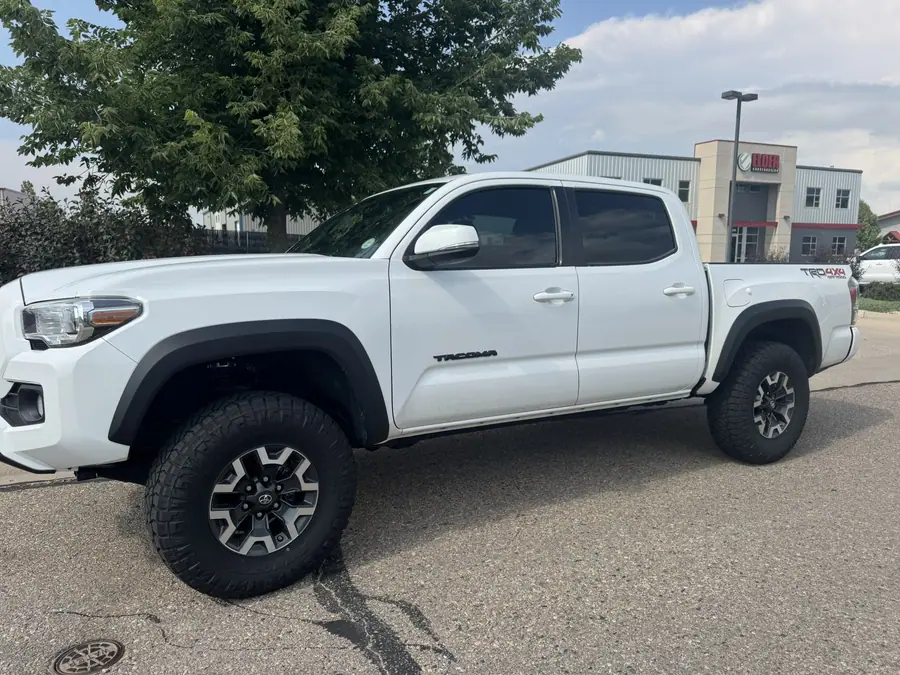 White 3rd gen Toyota Tacoma TRD Off-Road with a leveling kit and all-terrain tires