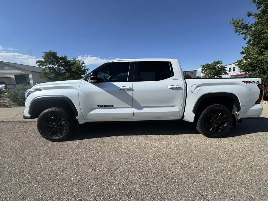 White 3rd gen Toyota Tundra with a leveling kit and black wheels