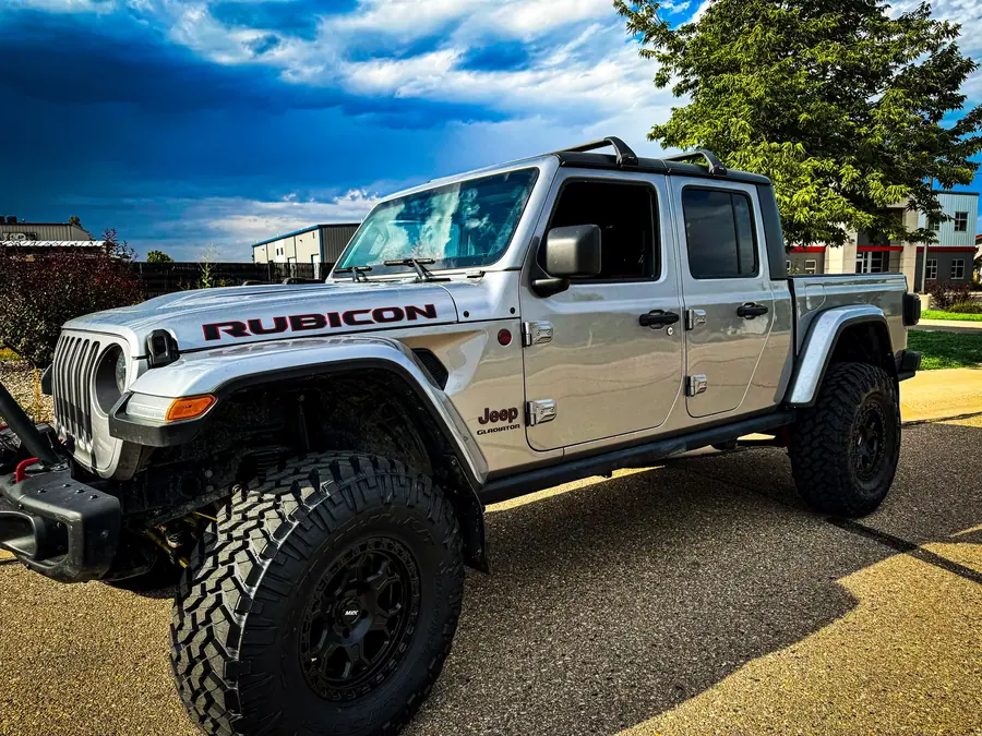 Lifted silver Jeep Gladiator Rubicon on large mud-terrain tires