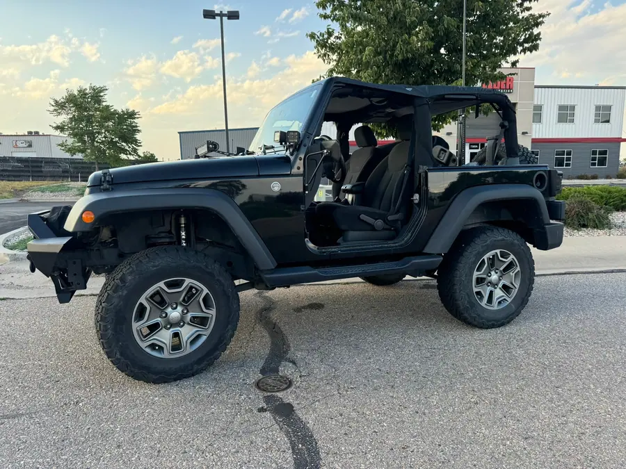 Black lifted two-door Jeep Wrangler JK with the doors off