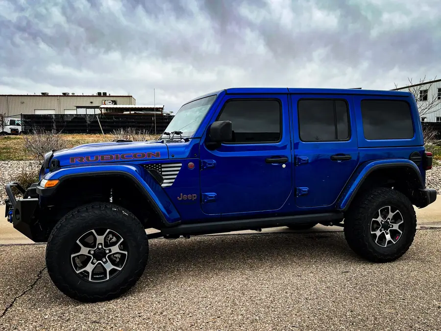 Blue lifted Jeep Wrangler JL Rubicon four-door with a steel front bumper
